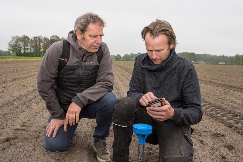 Pieter van Leeuwen-Boomkamp in gesprek met WUR expert Jean-Marie Michielsen bij een vochtensor in de uien.
